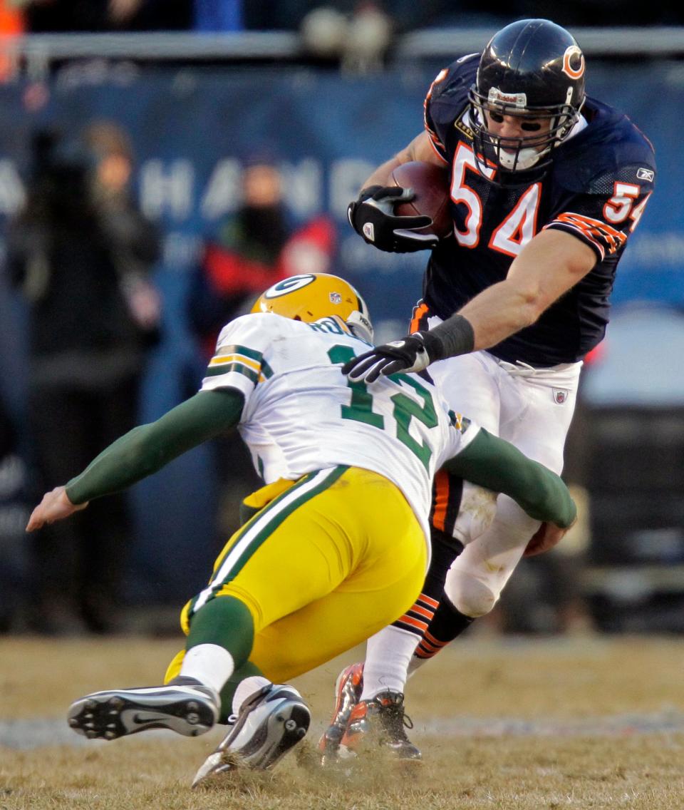 Chicago Bears linebacker Brian Urlacher is tackled by Green Bay Packers quarterback Aaron Rodgers after picking off a pass he threw during the third quarter of their NFC Championship game Sunday, January 23, 2011 at Soldier Field in Chicago, Ill.