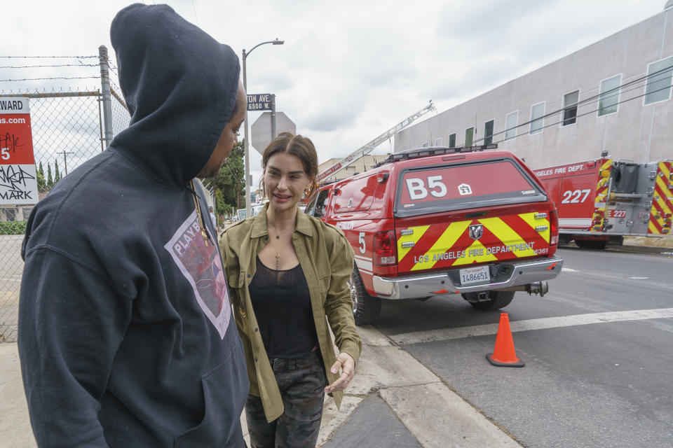 English actress and singer Aimée Osbourne, who creates electropop music under the name ARO, left, thanks music producer Jamal Rajad Davis, outside a Hollywood recording studio in Los Angeles Friday, May 20, 2022 in Los Angeles. Ozzy Osbourne's daughter Aimee and her producer escaped a Hollywood recording studio fire that killed another person, her mother said.(AP Photo/Damian Dovarganes)