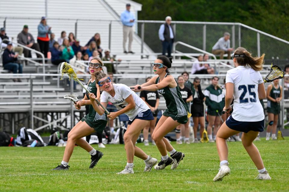 Avery Nistl of Hamilton-Wenham looks to pass the ball while pressured by Jayden Lilburn of Nipmuc Regional during the MIAA Division 4 girls lacrosse state tournament game at Hamilton Wenham High School, Wednesday, June 7, 2023. Hamilton-Wenham defeated Nipmuc Regional 16-8.