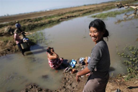 Women wash clothes and bath at a river in the outskirts of capital Naypyitaw, January 24, 2012.