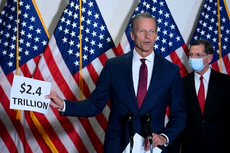 Senator Thune holds a sign while speaking at a news conference at the U.S. Capitol in Washington