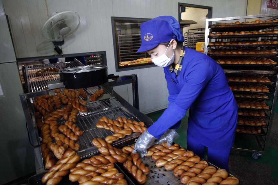FILE - In this Oct. 28, 2020, file photo, an employee oversees the making of bread items at the Songdowon General Foodstuff Factory in Wonsan, Kangwon Province, North Korea. North Korea is staging an “80-day battle,” a propaganda-heavy productivity campaign meant to bolster its internal unity and report greater production in various industry sectors ahead of a ruling party congress in January. (AP Photo/Jon Chol Jin, File)