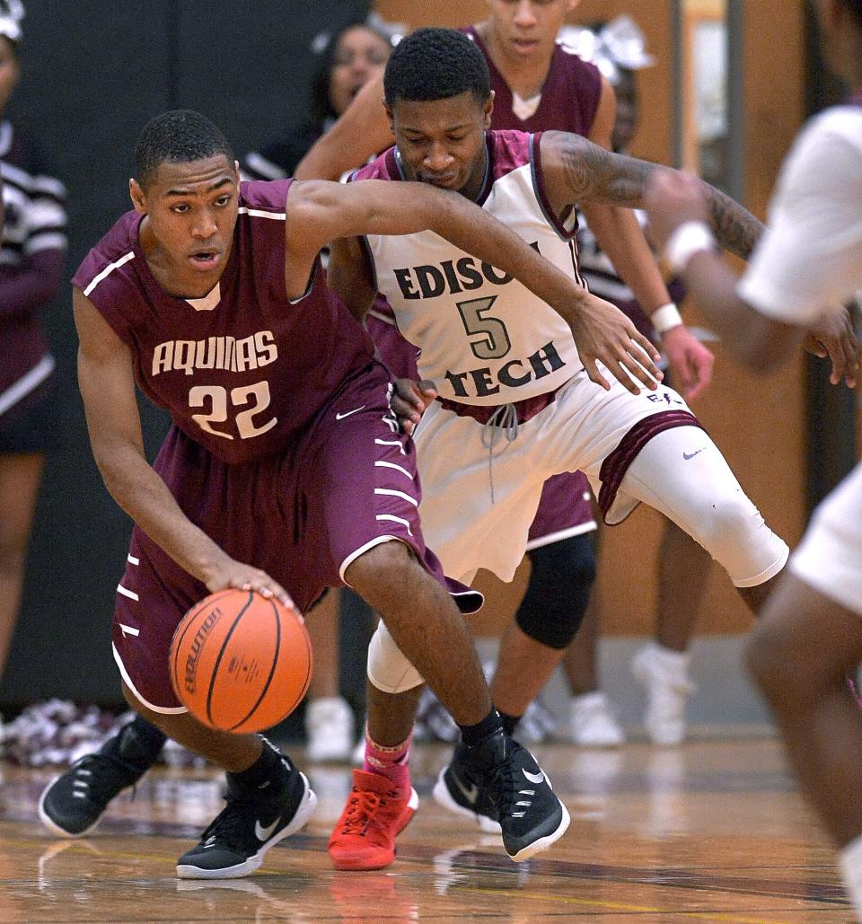 Aquinas' Jalen Pickett shields the ball from Edison's Marique Simkin during a game in 2016.