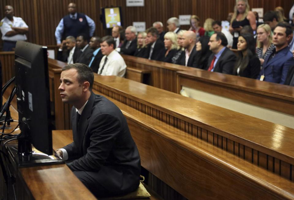 Oscar Pistorius sits in the dock prior to the start of his trial at the high court in Pretoria, South Africa, Monday, March 3, 2014. Pistorius is charged with murder with premeditation in the shooting death of girlfriend Reeva Steenkamp in the pre-dawn hours of Valentine's Day 2013. (AP Photo/Themba Hadebe, ool)