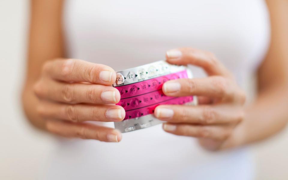 Woman's hand holding birth control pill - PhotoAlto/Antoine Arraou