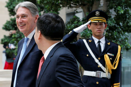 Chancellor of the Exchequer, Philip Hammond (L) is welcomed by Bank of China Chairman Tian Guoli before UK-China High Level Financial Services Roundtable at the Bank of China head office building in Beijing, China July 22, 2016. REUTERS/Damir Sagolj