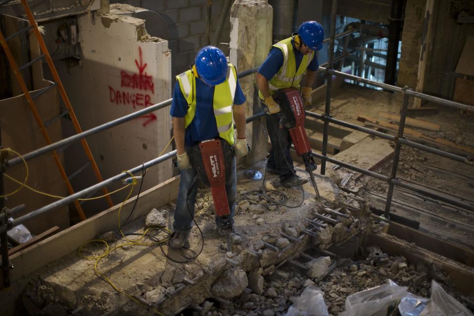 Builders pose for photographers as they carry out work on a new indoor venue at Shakespeare's Globe during an event for the media in London, Tuesday, Nov. 27, 2012. The new venue is named the Sam Wanamaker Theatre after the late American actor-director who spent decades realizing his dream of rebuilding Shakespeare's playhouse. It is due to open in January 2014, and will allow the Globe to hold performances year-round. (AP Photo/Matt Dunham)