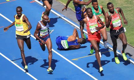 2016 Rio Olympics - Athletics - Preliminary - Men's 5000m Round 1 - Olympic Stadium - Rio de Janeiro, Brazil - 17/08/2016. Mo Farah (GBR) of Britain runs as Mead Hassan (USA) of USA falls after they nealy collided. REUTERS/Dominic Ebenbichler