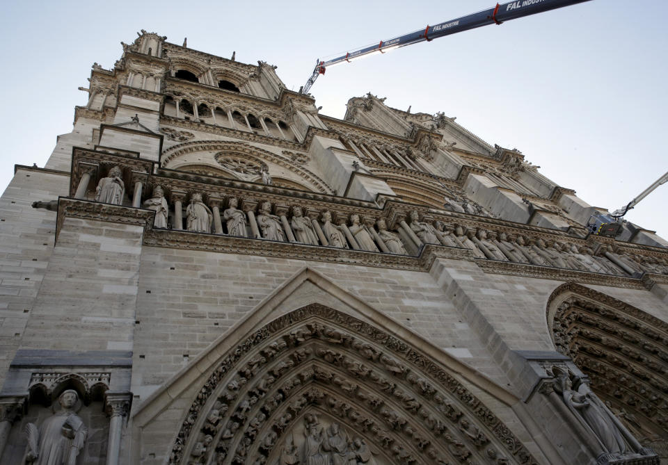 A crane works at Notre-Dame cathedral in Paris, Friday, April 19, 2019. Rebuilding Notre Dame, the 800-year-old Paris cathedral devastated by fire this week, will cost billions of dollars as architects, historians and artisans work to preserve the medieval landmark. (Philippe Wojazer/Pool via AP)