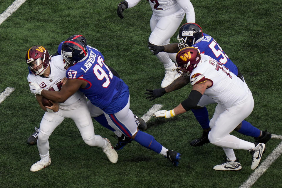 New York Giants defensive tackle Dexter Lawrence II (97) sacks Washington Commanders quarterback Sam Howell (14) during the second quarter of an NFL football game, Sunday, Oct. 22, 2023, in East Rutherford, N.J. (AP Photo/Seth Wenig)