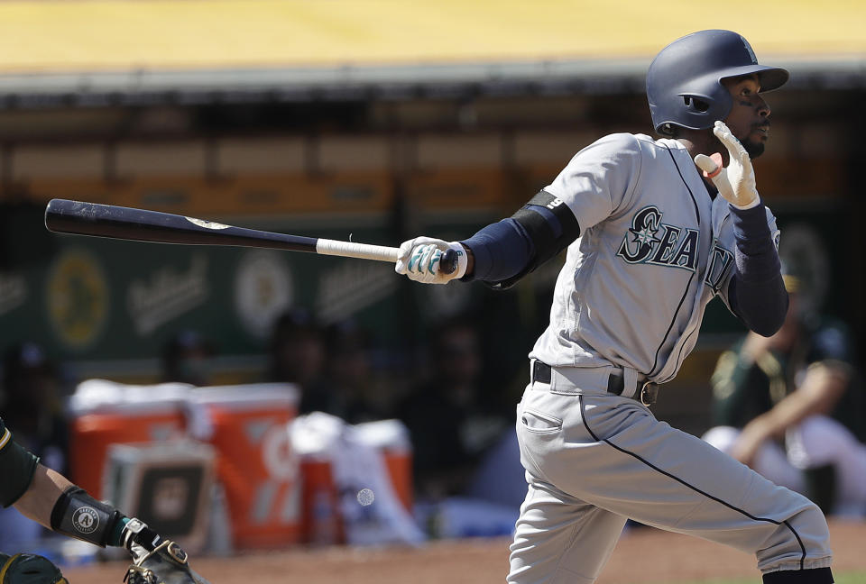 Seattle Mariners' Dee Gordon watches a two-run home run against the Oakland Athletics during the 12th inning of a baseball game in Oakland, Calif., Wednesday, Aug. 15, 2018. (AP Photo/Jeff Chiu)