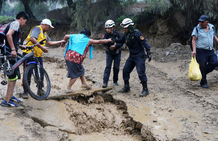 Residents try to cross a mudslide near the Central Highway after the Rimac river overflowed in Huarochiri, Lima, Peru, March 23, 2017. REUTERS/Guadalupe Pardo