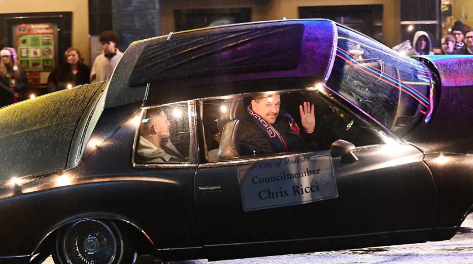 Modesto councilmember Chris Ricci waves to the crowd from a tilted Chevy Impala during the Celebration of Lights holiday parade in Modesto, Calif., Saturday, Dec. 3, 2022.