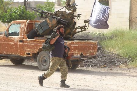 A member of al Qaeda's Nusra Front carries his weapon as he moves towards his position during an offensive to take control of the northwestern city of Ariha from forces loyal to Syria's President Bashar al-Assad, in Idlib province May 28, 2015. REUTERS/Ammar Abdullah