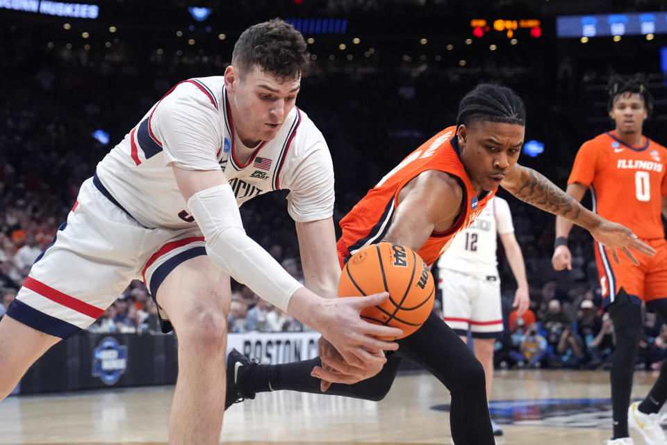 UConn center Donovan Clingan, left, battles Illinois guard Justin Harmon, right, for a loose ball during the first half of the Elite 8 college basketball game in the men's NCAA Tournament, Saturday, March 30, 2024, in Boston. (AP Photo/Steven Senne)