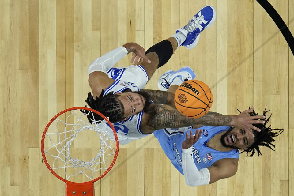 Duke forward Theo John, right, blocks the shot of North Carolina guard R.J. Davis during the first half of a college basketball game in the semifinal round of the Men's Final Four NCAA tournament, Saturday, April 2, 2022, in New Orleans. (AP Photo/Brynn Anderson)