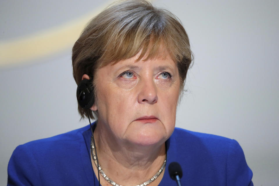 German Chancellor Angela Merkel reacts as she attends a press conference with Ukraine's President Volodymyr Zelenskiy, French President Emmanuel Macron, Russian President Vladimir Putin, at the Elysee Palace in Paris, Monday Dec. 9, 2019. Russian President Vladimir Putin and Ukrainian President Volodymyr Zelenskiy met for the first time Monday at a summit in Paris to try to end five years of war between Ukrainian troops and Russian-backed separatists. (Charles Platiau/Pool via AP)