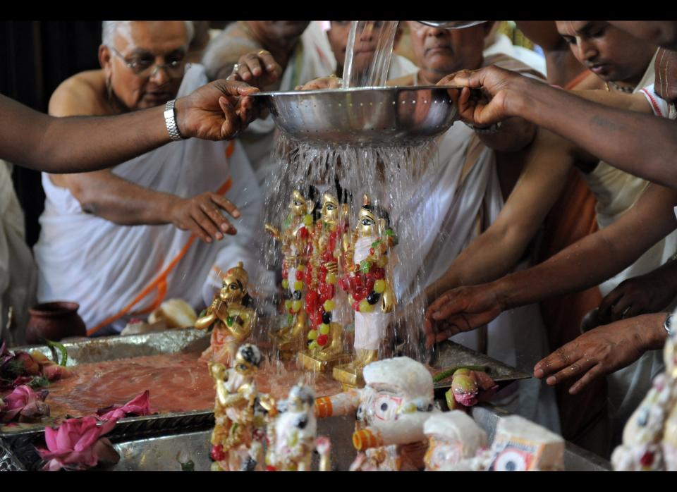 Hindu priest wash statuettes of the Hindu deities Hanuman, Laxman, Lord Rama and Goddess Sita at the International Society for Krishna Consciousness (ISKCON) temple in Ahmedabad, on the occasion of Rama Navami.