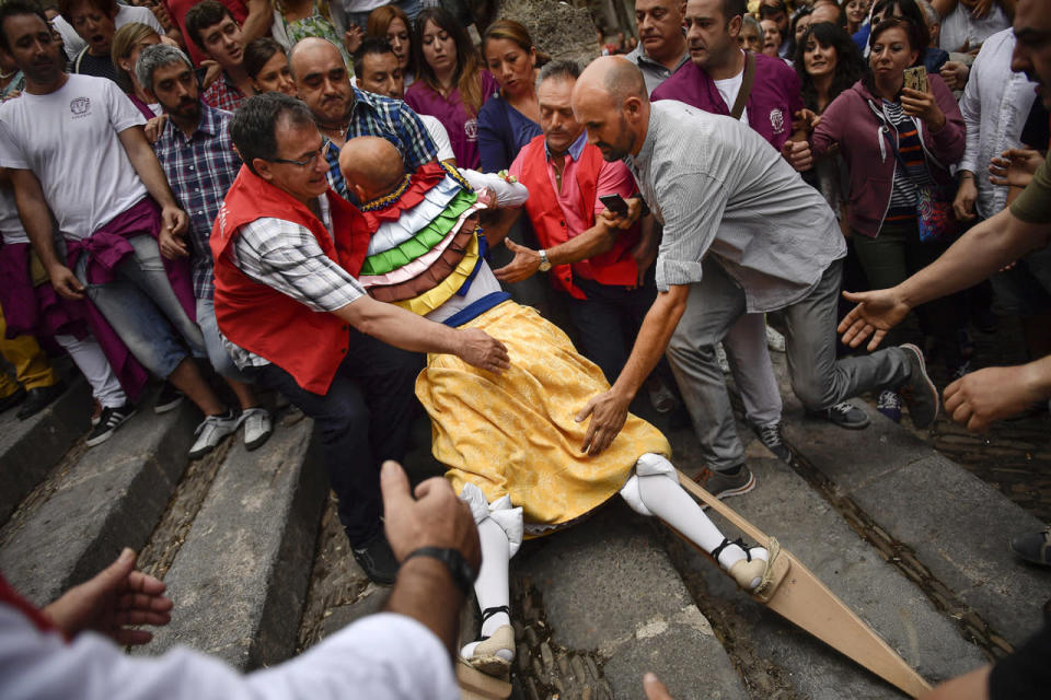 <p>People surround dancers as they perform on stilts in honor of Saint Mary Magdalene in a street for the traditional “Danza de Los Zancos” (Los Zancos Dance), in the small town of Anguiano, northern Spain, July 23, 2016. (AP Photo/Alvaro Barrientos)</p>