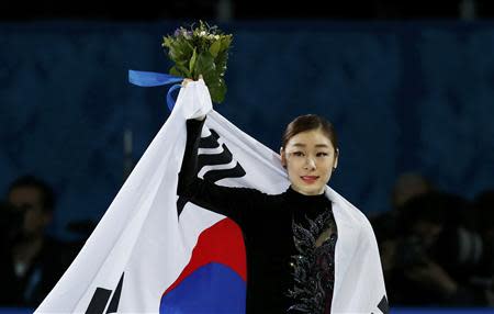 Korea's Yuna Kim celebrates holding her flag at the end of the Figure Skating Women's free skating Program at the Sochi 2014 Winter Olympics, February 20, 2014. REUTERS/Alexander Demianchuk