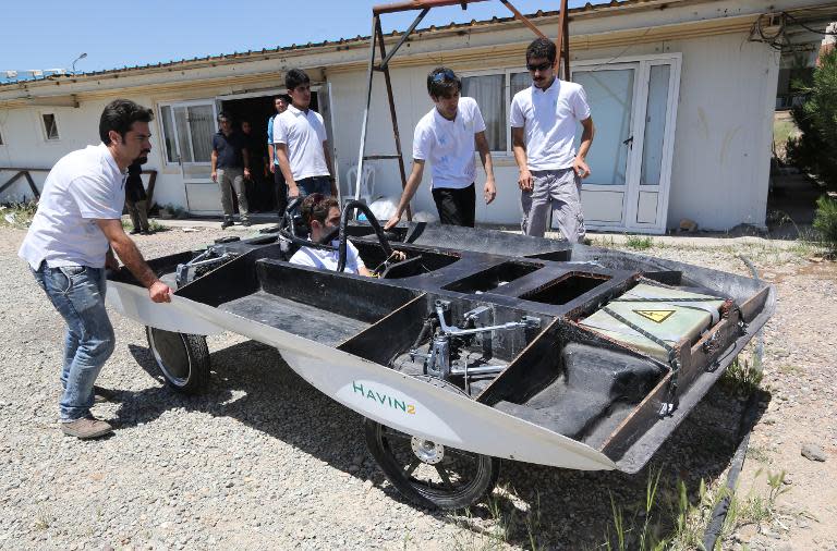 Iranian students from Qazvin Azad Islamic University assemble the solar-powered Havin-2 vehicle for a test drive in Qazvin on June 2, 2014