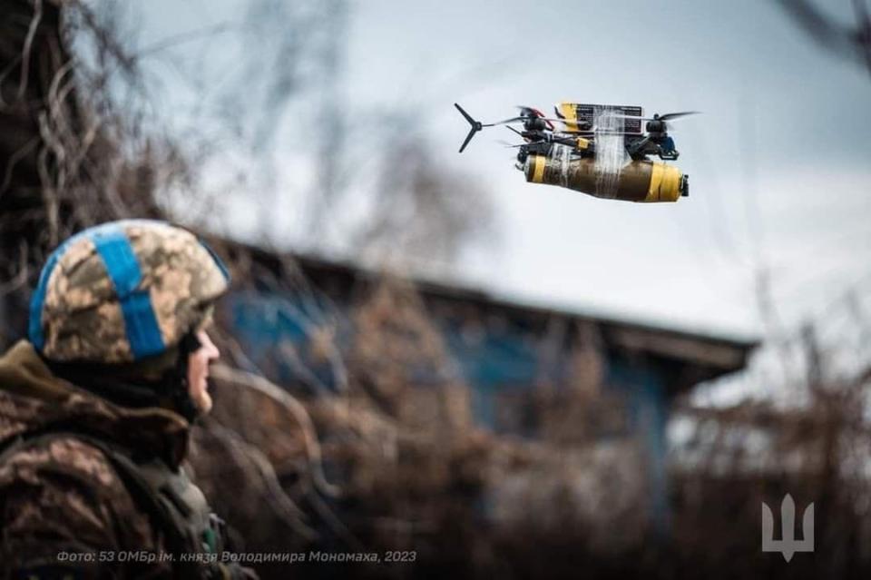A Ukrainian drone operator piloting a quadcopter-style drone with a bomb strapped to it.