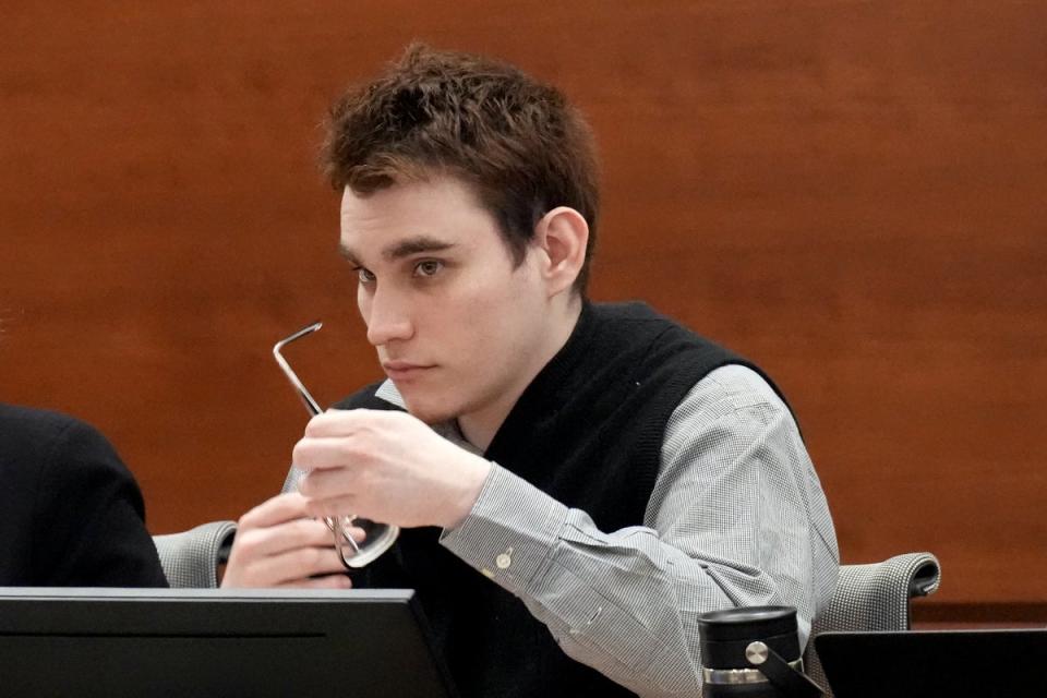 Nikolas Cruz cleans his glasses as he listens in court on Friday 2 September (Getty Images)