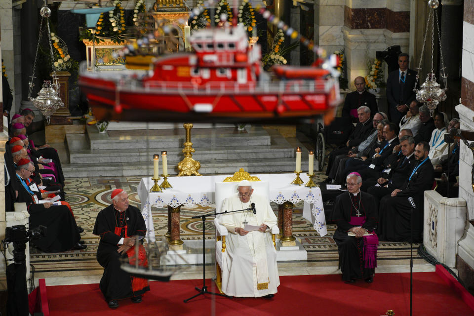 A model boat hanging from the ceiling of the Notre Dame de la Garde Basilica is seen as Pope Francis delivers his speech during a Marian prayer with the diocesan clergy, in Marseille, France, Friday, Sept. 22, 2023. Francis, during a two-day visit, will join Catholic bishops from the Mediterranean region on discussions that will largely focus on migration. (AP Photo/Daniel Cole)
