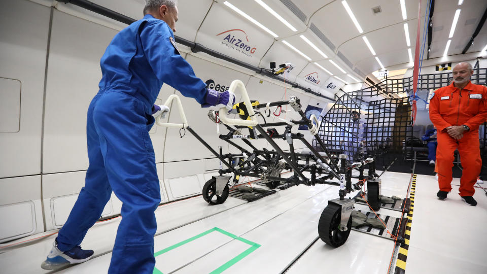 Scientists testing moon exploration equipment during a parabolic flight simulating lunar gravity.