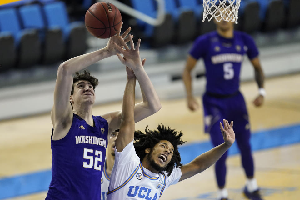 UCLA guard Tyger Campbell, right, breaks up a shot by Washington center Riley Sorn (52) during the first half of an NCAA college basketball game Saturday, Jan. 16, 2021, in Los Angeles. (AP Photo/Ashley Landis)