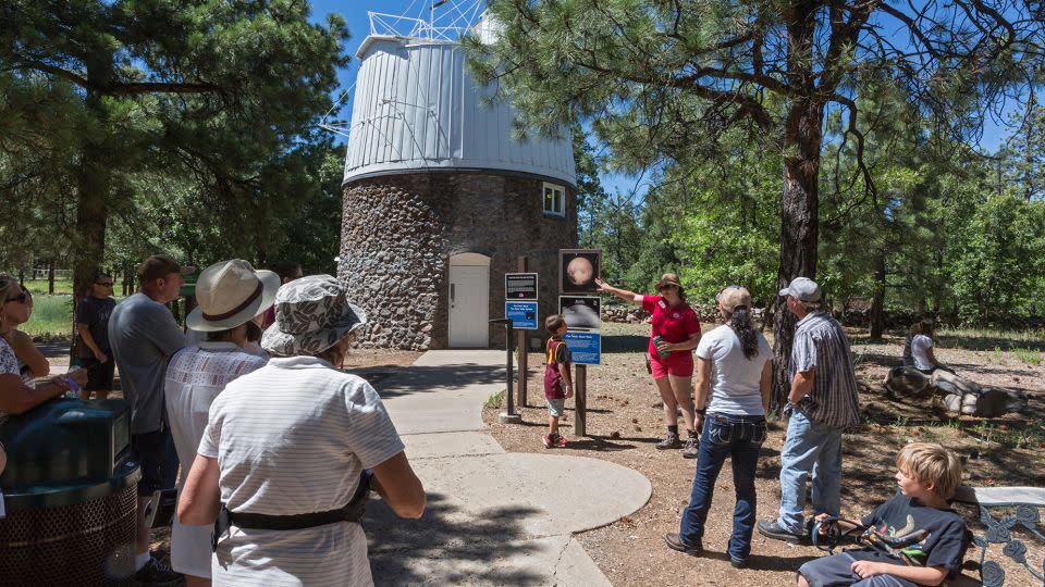 A guide tells visitors to the Lowell Observatory about the Pluto Discovery Dome. Pluto was discovered at the observatory on February 18, 1930. - Jim West/Alamy Stock Photo