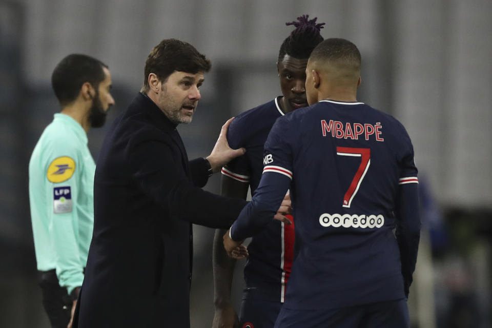 El técnico del PSG Mauricio Pochettino (izquierda) charla con Kylian Mbappé (derecha) durante el partido contra el Olympique de Marsella por la liga francesa, el domingo 7 de febrero de 2021. (AP Foto/Daniel Cole)