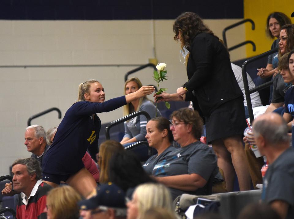 Airport senior Julia Mills hands a flower to one of several spectators who have battled ovarian cancer at the seventh Annual Teal Attack volleyball match Wednesday, September 22, 2021.