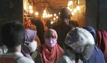 Muslim women wear face masks as they shop in preparation of the upcoming Eid al-Fitr holiday that marks the end of the holy fasting month of Ramadan amid fears of the new coronavirus outbreak at a market in Jakarta, Indonesia, Friday, May 22, 2020. (AP Photo/Achmad Ibrahim)