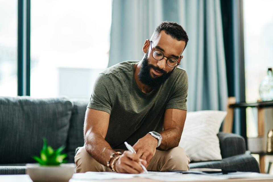 Person sitting on a couch looking at paperwork.