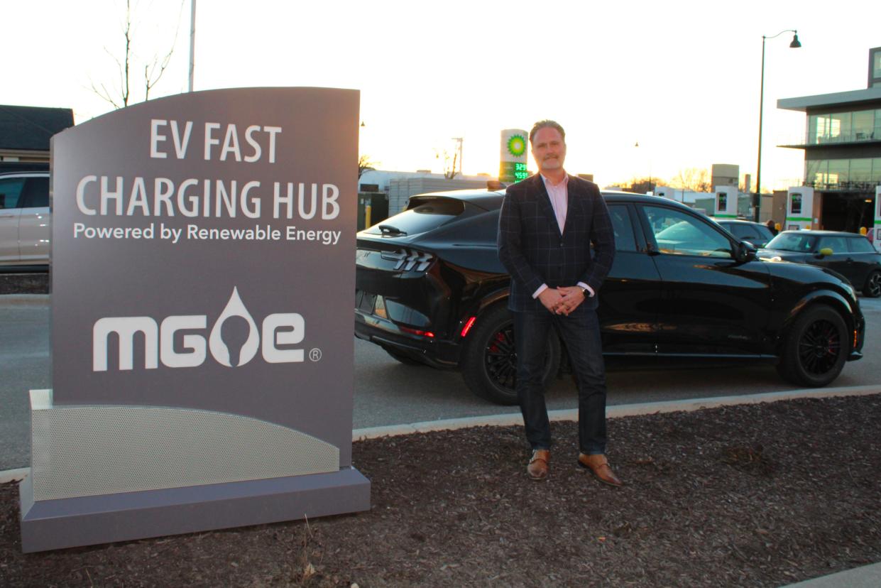 Zach Brandon of Madison, Wisconsin, stands beside a public charging network in his hometown on Thursday, Feb. 29, 2024. He said getting a free charging adapter for his 2023 Ford Mustang Mach-E GT Premium SUV to access the Tesla Superchargers network is a "game changer."