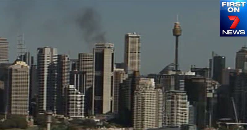 Smoke billows behind the Sydney city skyline as a unit block at Centennial Park burns. Photo: First on 7News