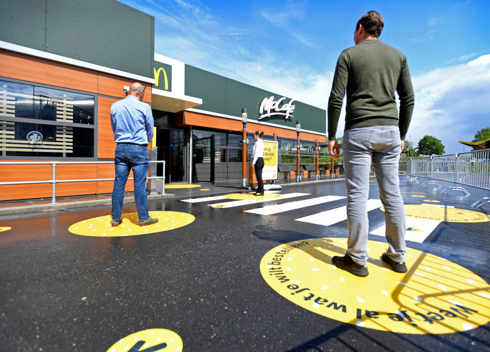 Customers wait outside on social distancing markings at a prototype location of fast food giant McDonald's for restaurants which respect the 1.5m social distancing measure, amid the coronavirus disease (COVID-19) outbreak, in Arnhem, Netherlands, May 1, 2020. REUTERS/Piroschka van de Wouw