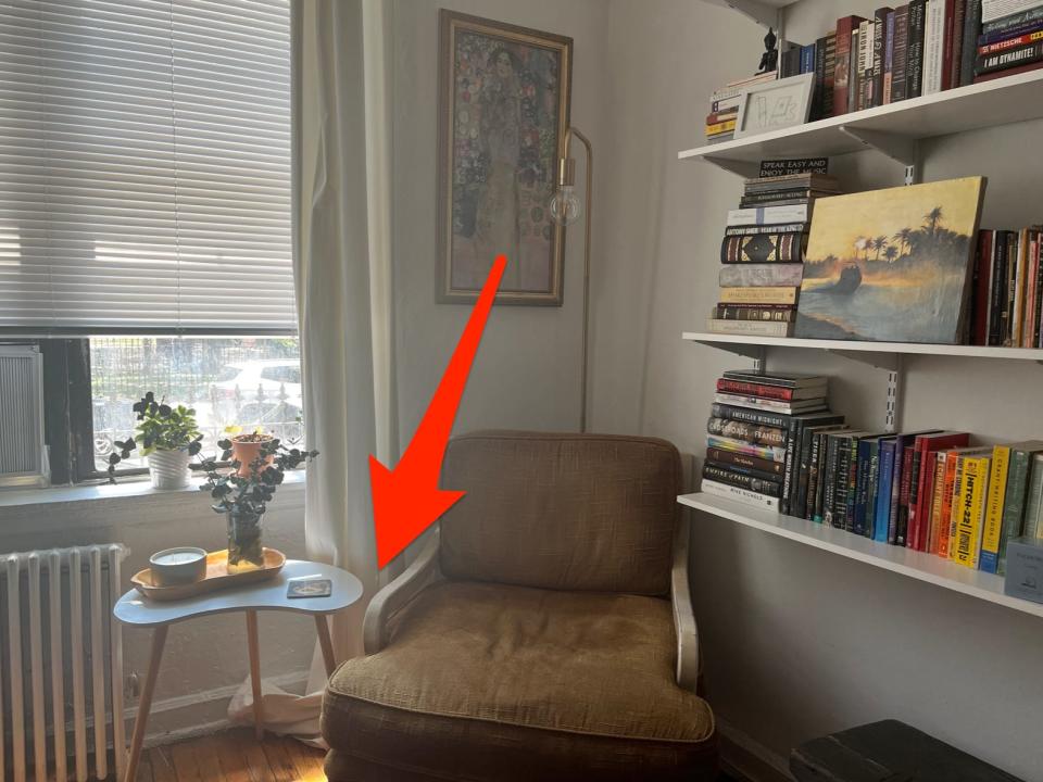 Living room with chair and white curtains pooling on the ground with red arrow point toward them