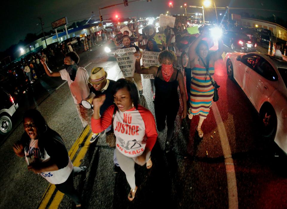 Protestors in Ferguson, Mo., march in 2014 after unarmed black teenager Michael Brown was shot and killed by a white police officer. Differing eyewitness accounts in this case and the death of Freddy Gray in police custody in 2015 led the national call for police body cameras.