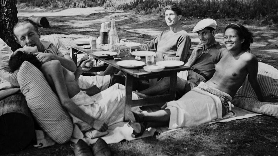 Miller’s close friendships with other artists led to her taking now-famous candid images of the era, including this photograph of the poet and artist Paul and Nusch Éluard (left); Miller's eventual husband, Roland Penrose (back right); and the artist Man Ray and model Ady Fidelin (right). - Lee Miller Archives, England 2023