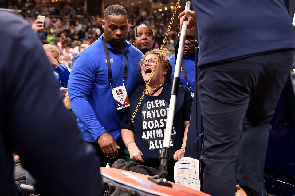 A activist chains herself to the goal during the Memphis Grizzlies-Minnesota Timberwolves first-round NBA playoff game at FedExForum on April 16, 2022.