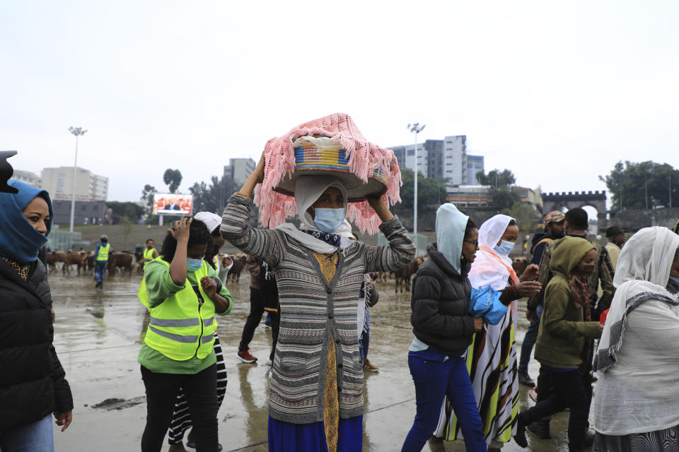 Women bring food to give to the youth joining the Defense Forces, at Meskel Square, in Addis Ababa, Ethiopia, Tuesday, July 27 2021. A repatriation program is underway for young people from Ethiopia who have decided to join the Defense Forces. (AP Photo)