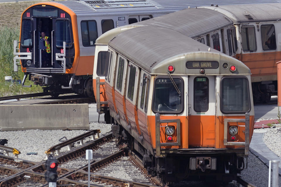 An older Orange Line subway train, right, passes a new Orange Line subway train at the Wellington Station train yard, Wednesday, July 13, 2022, in Medford, Mass. Boston's public transit system is a mess, harried commuters and officials are increasingly looking to a Chinese-owned subway car manufacturer to account for some of the troubles. There have been fatal accidents, subway car collisions, malfunctioning elevators, and trains running on weekend schedules during rush hour. (AP Photo/Charles Krupa)