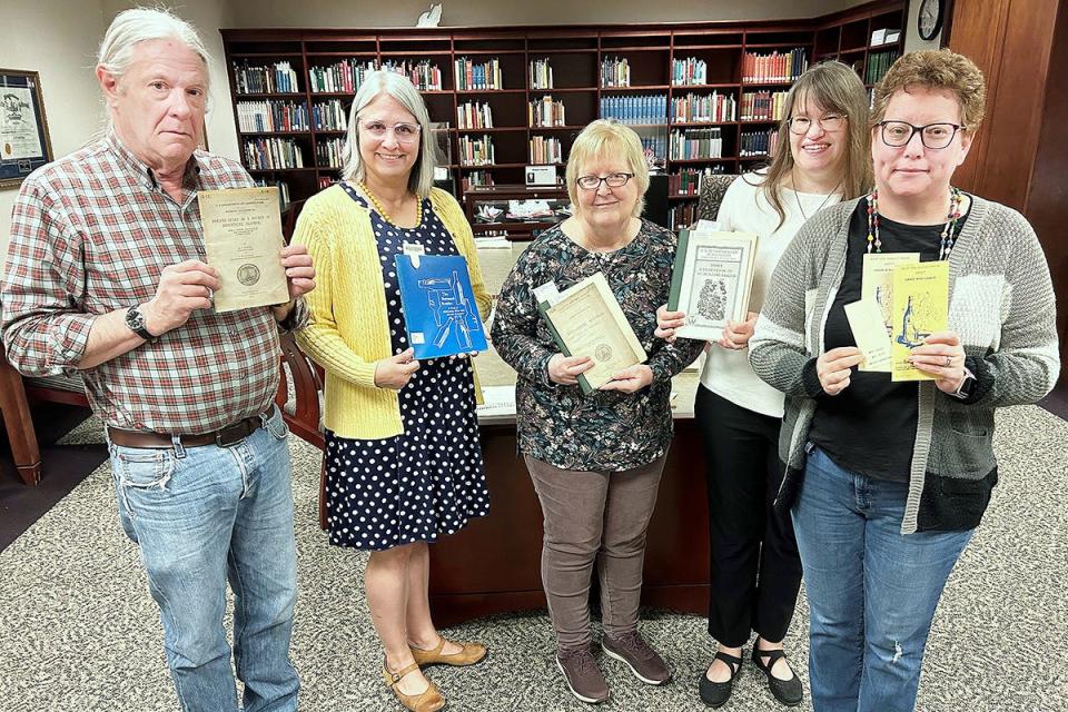 MTSU James E. Walker Library Special Collections staff holding items in the Distilling, Fermenting and Brewing Collection are, from left, Alan Boehm, head of Special Collections; Susan Martin, chair of collection development and management; Susan Hanson, Special Collections cataloguing; Beverly Geckle, continuing resources librarian and Federal Depository Library coordinator; and Toni Butler Click, continuing resources coordinator and federal documents assistant.