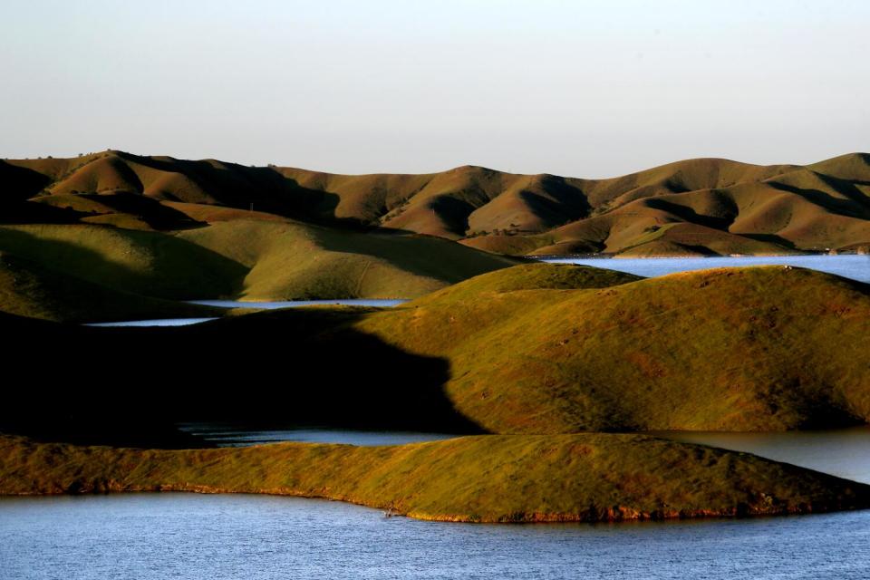 Grassy hills interspersed with blue water.