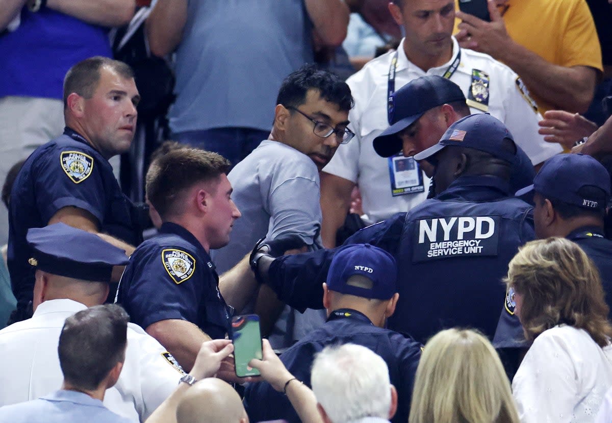 A demonstrator is removed from the Arthur Ashe Stadium by New York City Police (REUTERS)