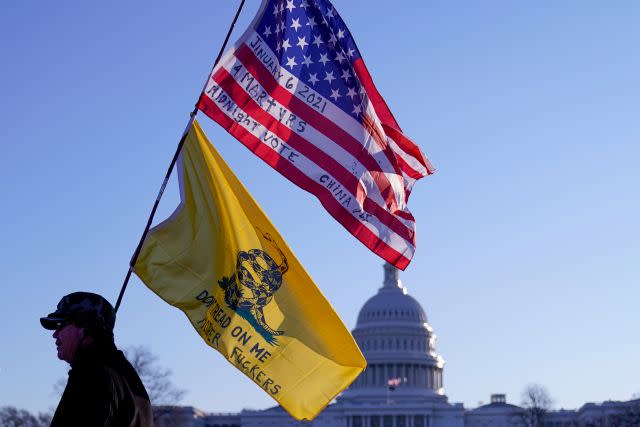 A man walks with a Gadsden and American flags outside the U.S. Capitol, a day after supporters of U.S. President Donald Trump occupied the U.S. Capitol Building in Washington, U.S. January 7, 2021. REUTERS/Erin Scott