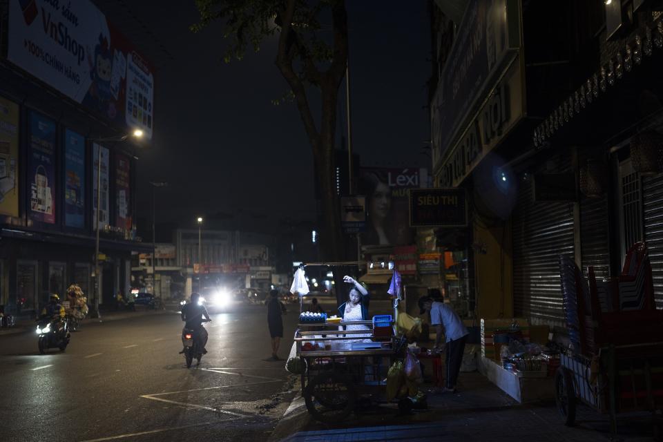 A food vendor wipes her face while preparing for business in Ho Chi Minh City, Vietnam, Jan. 12, 2024. (AP Photo/Jae C. Hong)