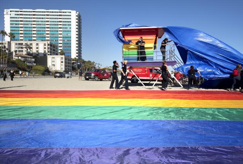 LONG BEACH, CA - JUNE 10: The wind made it slightly challenging for the unveiling of the new rainbow-colored lifeguard tower at Long Beach to replace the one that was burned down in March. The tower serves as a symbol of LGBTQ+ pride. Photographed on Thursday, June 10, 2021 in Long Beach, CA. (Myung J. Chun / Los Angeles Times)